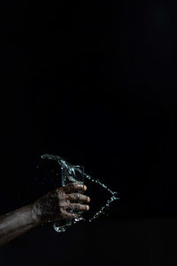 Person holding umbrella against black background