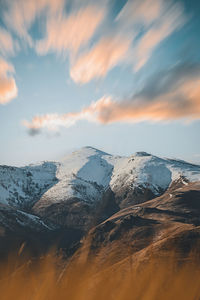 Aerial view of snowcapped mountains against sky during sunset