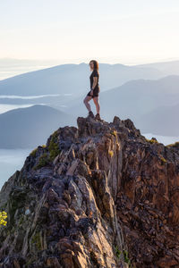 Woman standing on rock against mountain