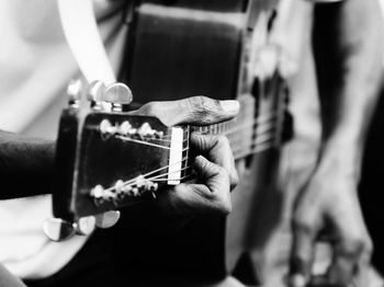 Midsection of man playing guitar