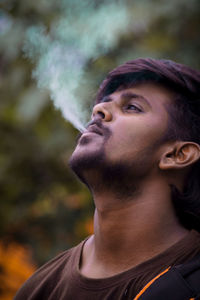 Portrait of young man smoking outdoors