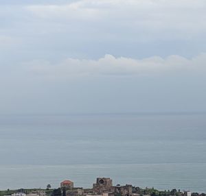 Scenic view of sea and buildings against sky