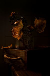 Close-up of wilted flower on table against black background