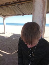 Rear view of boy on shore at beach