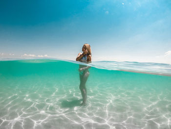Woman in swimming pool against sea
