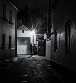 Man walking on illuminated street at night