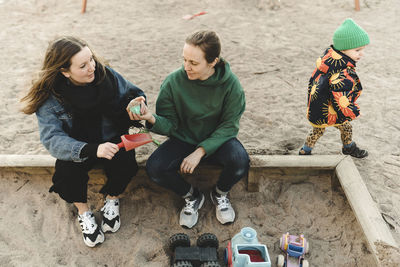 Women with daughter at sand pit
