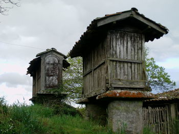 Old abandoned house on field against sky