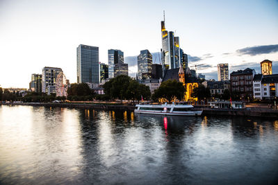 River by buildings against sky in city