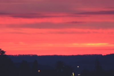 Silhouette trees against romantic sky at sunset