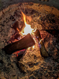 High angle view of bonfire on rock at night