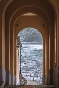 Sea seen through arch door of building