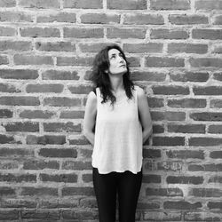 Woman standing against brick wall