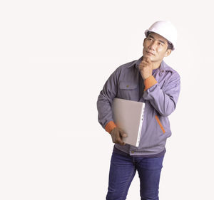 Man wearing hat standing against white background