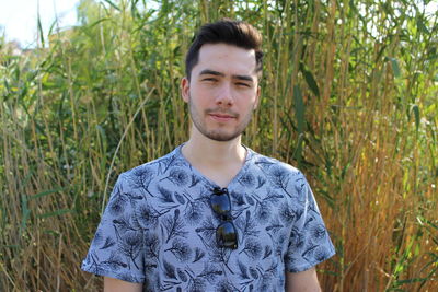 Portrait of young man standing on field