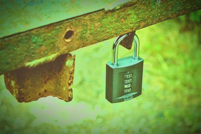 Close-up of padlocks hanging on rusty metal