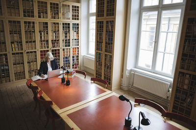 Senior woman researching at table in law library