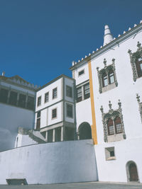 Low angle view of buildings against clear blue sky