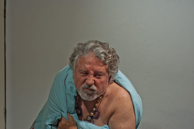 Portrait of senior man against wall