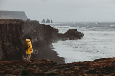 Man on cliff by sea