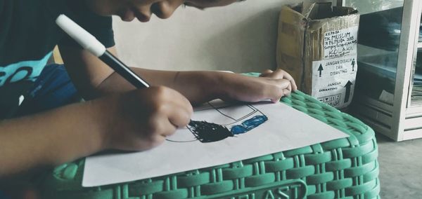 Midsection of man using mobile phone on table