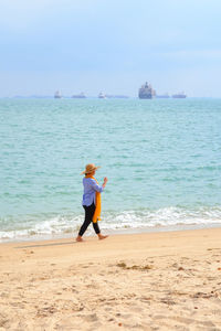 Full length of man on beach against sky