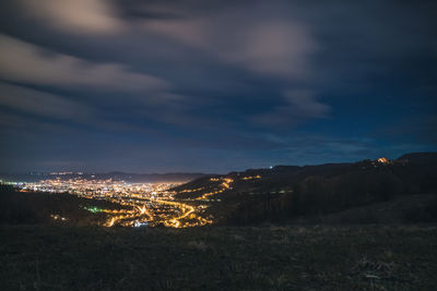 Illuminated cityscape against sky at night