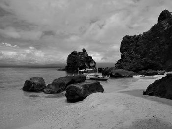 Scenic view of rock formation in sea against sky