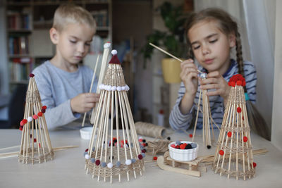 Cute sibling making decoration at home