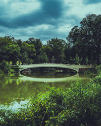 Arch bridge over lake against sky