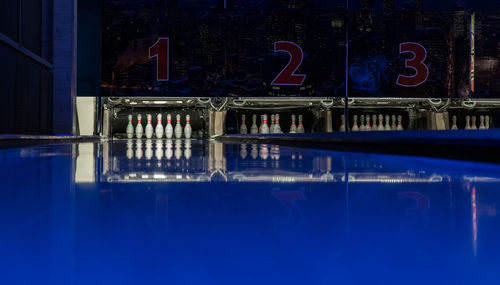 Reflection of illuminated building in swimming pool at night