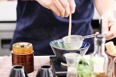 Midsection of man preparing food in glass