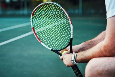 Midsection of man playing tennis