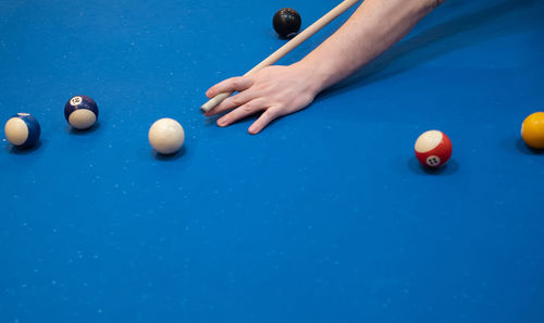 Cropped hand of woman playing pool