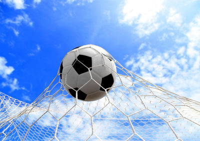 Soccer ball hitting in goal post against blue sky