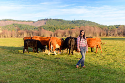 Portrait of teen girl with cows on pasture