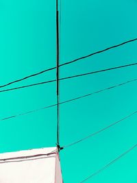 Low angle view of cables against clear blue sky