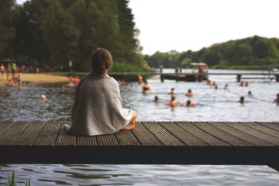 Rear view of woman sitting in river