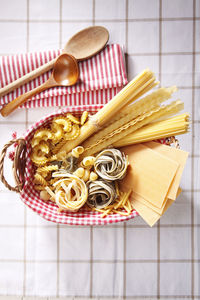 Directly above shot of various pastas in basket on fabric
