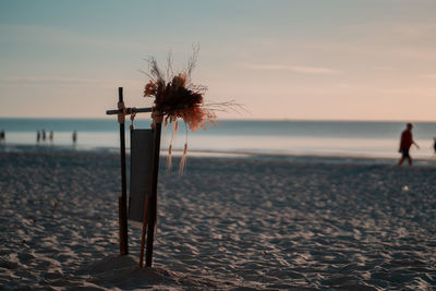 Lifeguard hut on beach against sky during sunset