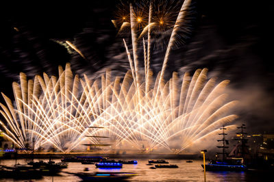 Firework display over river at night