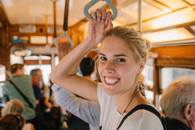 Close-up of smiling young woman in bus