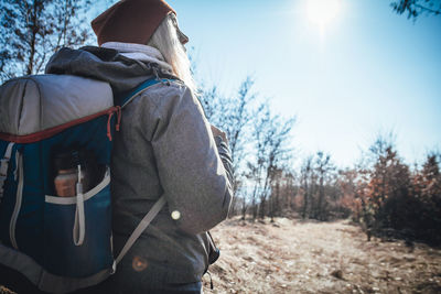 Rear view of man on field against sky during winter