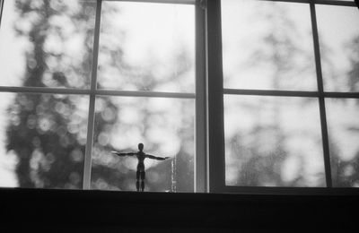 Low angle view of wooden figurine on window sill