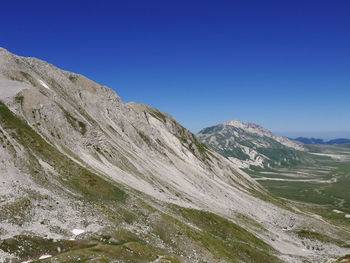 Scenic view of mountains against clear blue sky