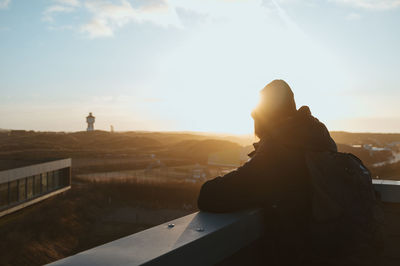 Rear view of man looking at sunset