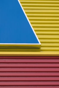 Close-up of multi colored shutter against blue sky