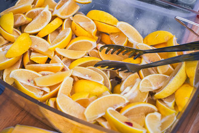 Slices of lemon in the glass bowl with tongs