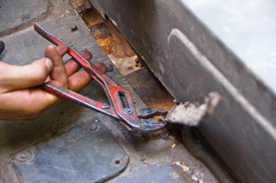 Close-up of hand cutting metal with pliers