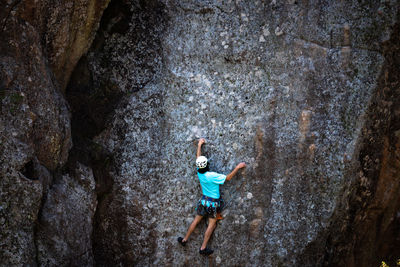 Rear view of boy standing on rock